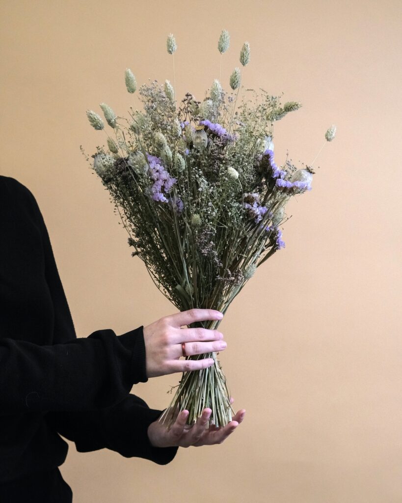 Bukiet z suchych kwiatów trzymany w rękach